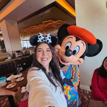 Dani Godinez con Mickey vestido de pintor en una comida con personajes en Walt Disney World