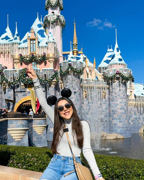 Dani Godinez frente al Castillo de la Bella Durmiente en Disneyland, California