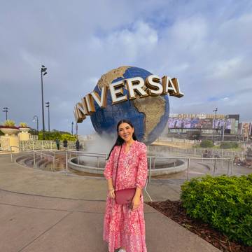 Dani Godinez frente al globo de Universal Studios en Universal Orlando