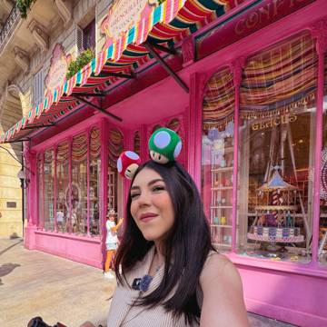 Dani Godinez con diadema de hongos de Mario frente a una dulcería en Epic Universe, Universal Orlando