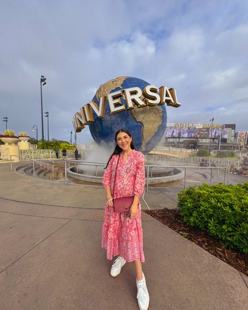Dani Godinez frente al globo de Universal Studios en Universal Orlando